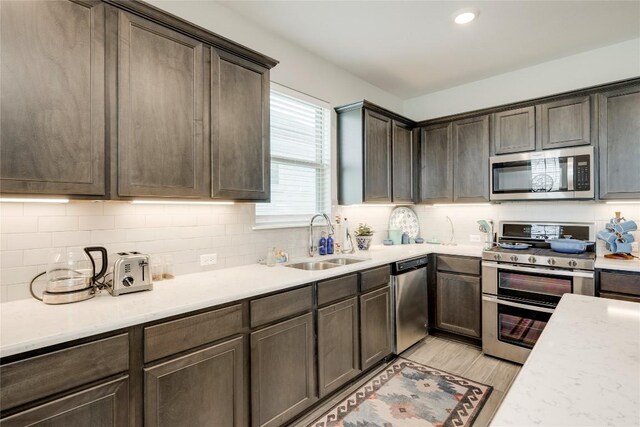 121 Harborside Dr Unit 102, San Marcos, TX 78666 - kitchen featuring stainless steel appliances, light wood finished floors, decorative backsplash, dark brown cabinetry, and recessed lighting