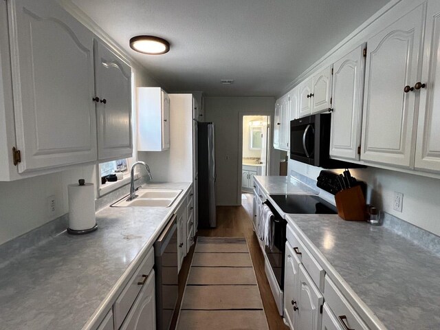 421 E Briarway Dr, Marble Falls, TX 78654 - kitchen with electric range, stainless steel dishwasher, white cabinetry, freestanding refrigerator, and black microwave