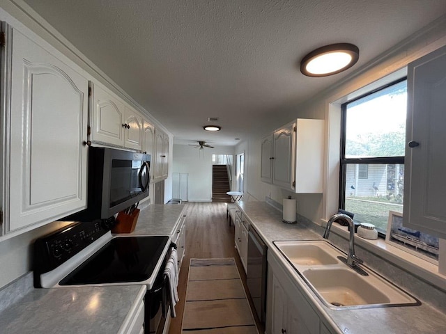 421 E Briarway Dr, Marble Falls, TX 78654 - kitchen with appliances with stainless steel finishes, a sink, healthy amount of natural light, white cabinets, and a textured ceiling