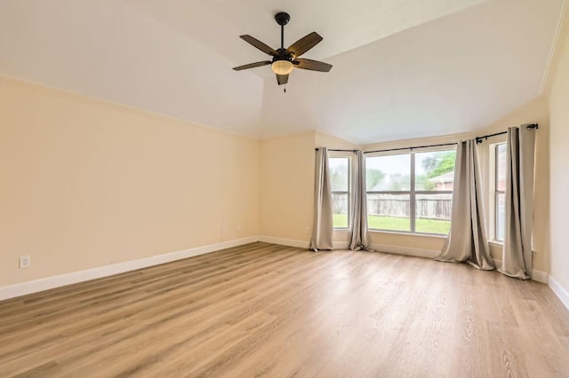empty room with a ceiling fan, lofted ceiling, baseboards, and light wood finished floors