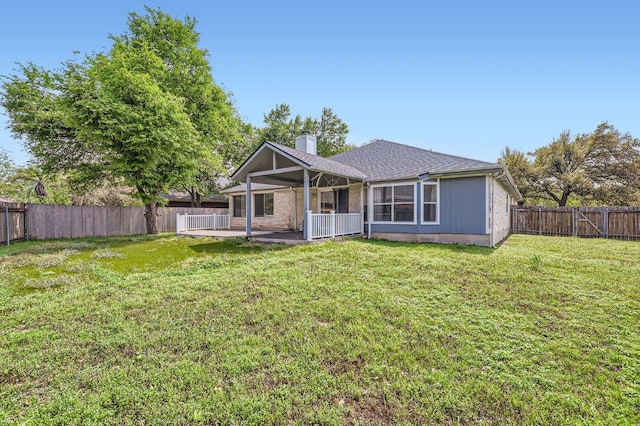 back of property featuring a fenced backyard, a patio, a chimney, and a lawn