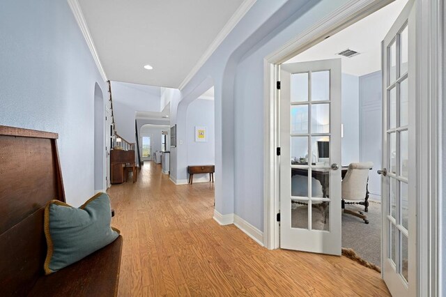 7721 Journeyville Dr, Austin, TX 78735 - corridor featuring arched walkways, light wood-style flooring, a desk, crown molding, and french doors