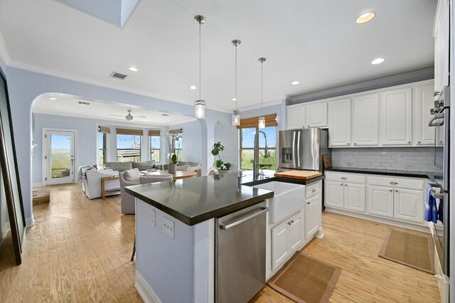 7721 Journeyville Dr, Austin, TX 78735 - kitchen with appliances with stainless steel finishes, arched walkways, a sink, dark countertops, and crown molding