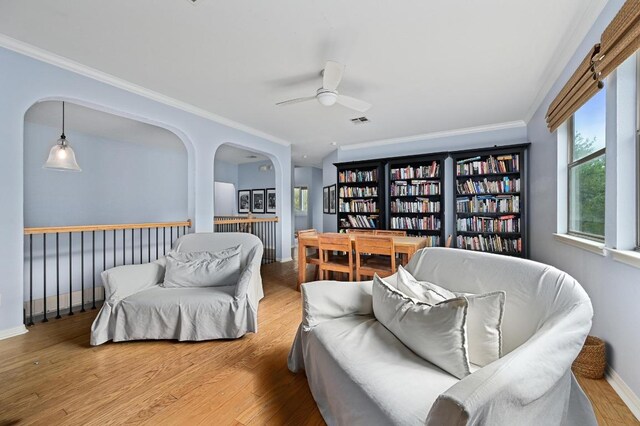 7721 Journeyville Dr, Austin, TX 78735 - sitting room featuring ceiling fan, ornamental molding, wood finished floors, baseboards, and arched walkways