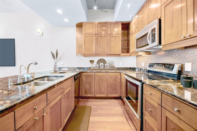 360 Nueces St Unit 3504, Austin, TX 78701 - kitchen featuring appliances with stainless steel finishes, a sink, light wood finished floors, dark stone counters, and recessed lighting
