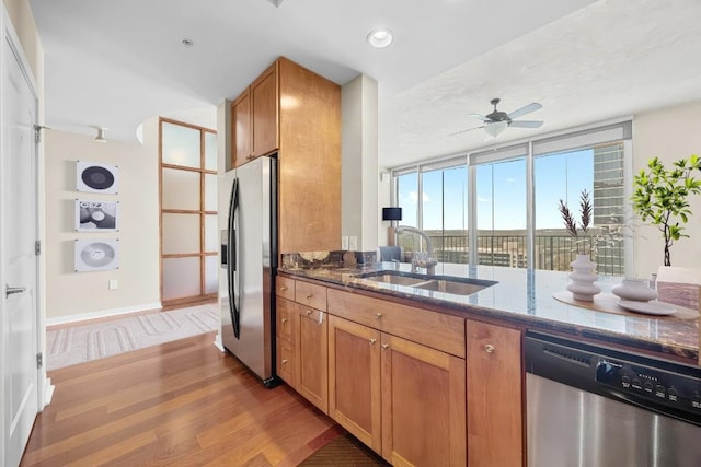 360 Nueces St Unit 3504, Austin, TX 78701 - kitchen featuring a sink, stainless steel appliances, light wood-style floors, dark stone countertops, and floor to ceiling windows