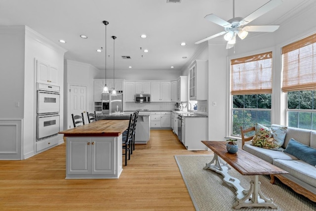 5305 Cuesta Verde, Austin, TX 78746 - kitchen featuring butcher block countertops, appliances with stainless steel finishes, crown molding, tasteful backsplash, and recessed lighting
