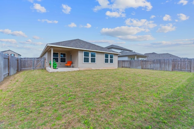 rear view of property featuring a patio, a fenced backyard, a lawn, and roof with shingles