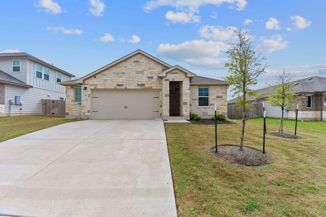 view of front facade featuring stone siding, an attached garage, a front yard, and driveway