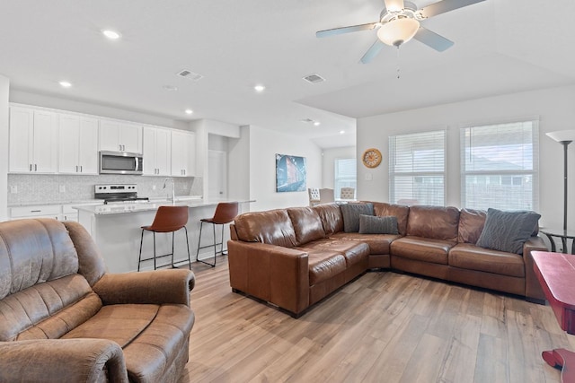 living area featuring visible vents, light wood-style flooring, and a ceiling fan