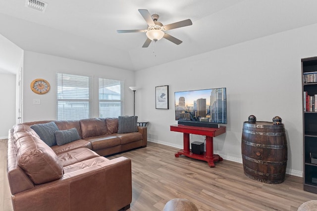 living room featuring lofted ceiling, light wood-type flooring, baseboards, ceiling fan, and visible vents