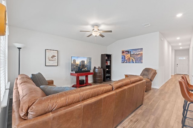 living room featuring a ceiling fan, lofted ceiling, light wood-style flooring, visible vents, and recessed lighting
