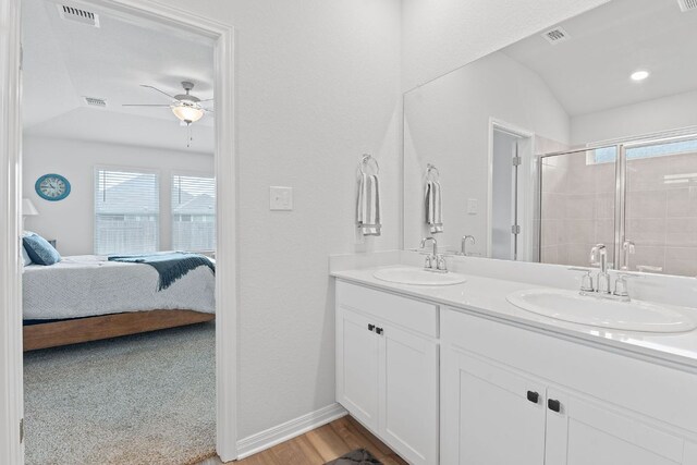 ensuite bathroom with visible vents, connected bathroom, a sink, and plenty of natural light