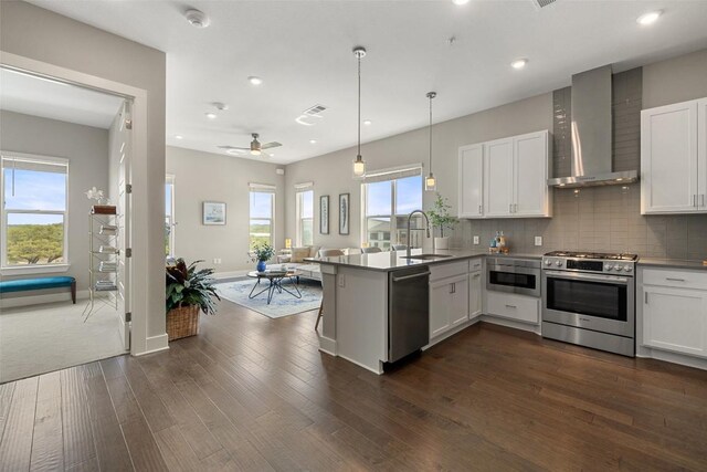 4501 Jackson Ave Unit 5205, Austin, TX 78731 - kitchen featuring appliances with stainless steel finishes, a sink, wall chimney exhaust hood, a peninsula, and open floor plan
