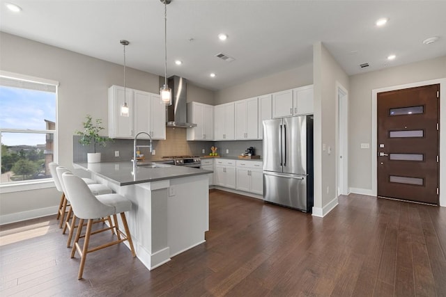 4501 Jackson Ave Unit 5205, Austin, TX 78731 - kitchen featuring appliances with stainless steel finishes, wall chimney range hood, a sink, a peninsula, and baseboards