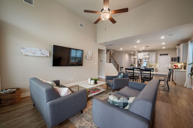 living area featuring stairs, a ceiling fan, wood finished floors, and visible vents