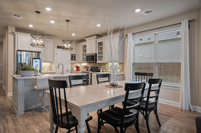 dining space featuring baseboards, dark wood-style flooring, and visible vents