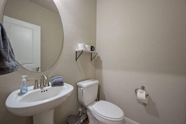 half bathroom featuring a sink and toilet