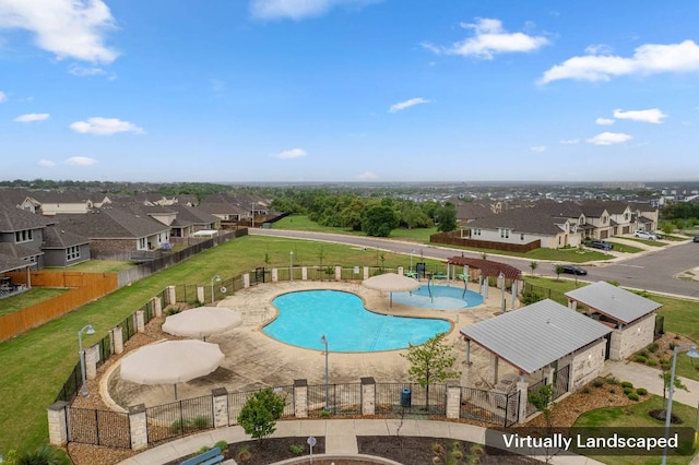 community pool with fence and a residential view