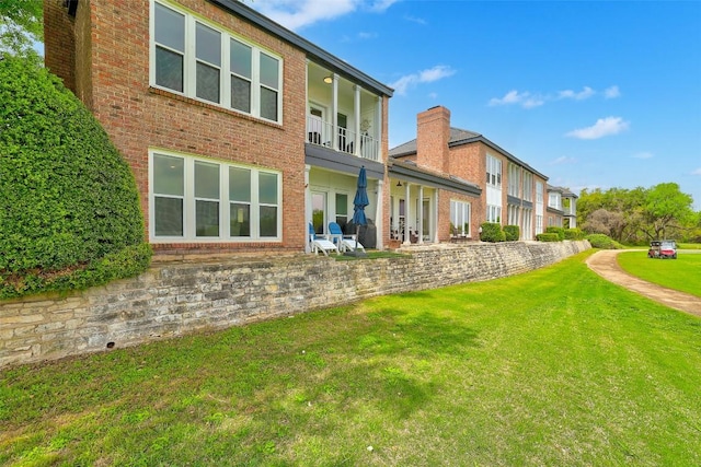 16 Tournament Way Unit 19, The Hills, TX 78738 - rear view of property featuring a lawn, brick siding, and a balcony