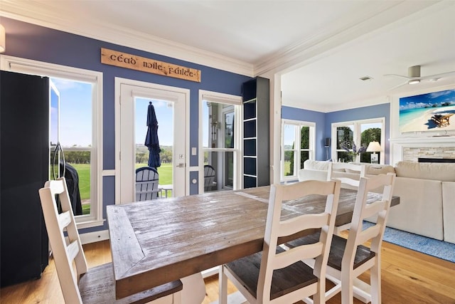 16 Tournament Way Unit 19, The Hills, TX 78738 - dining space with ornamental molding, wood finished floors, a ceiling fan, french doors, and a stone fireplace