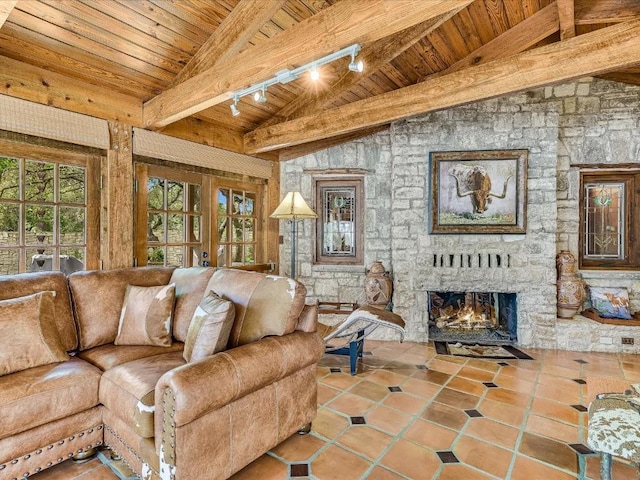 living area featuring a fireplace, tile patterned floors, lofted ceiling with beams, wooden ceiling, and rail lighting