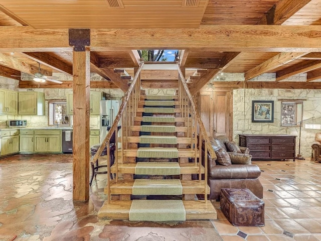 stairs with beam ceiling, wooden ceiling, and ceiling fan