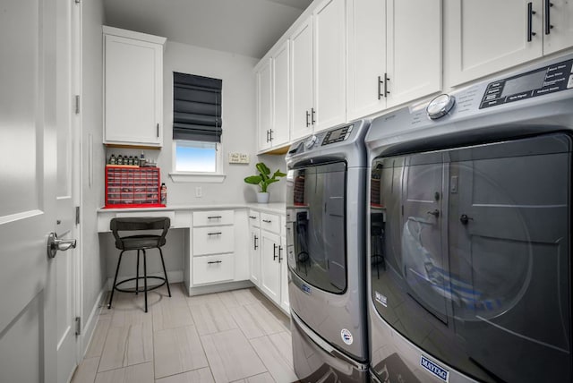 clothes washing area featuring washer and clothes dryer and cabinet space