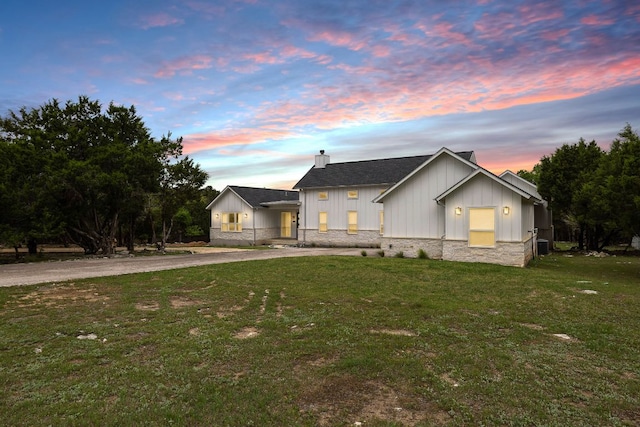 6601 N Lakewoods Dr, Georgetown, TX 78633 - modern farmhouse featuring a chimney, board and batten siding, a lawn, curved driveway, and stone siding