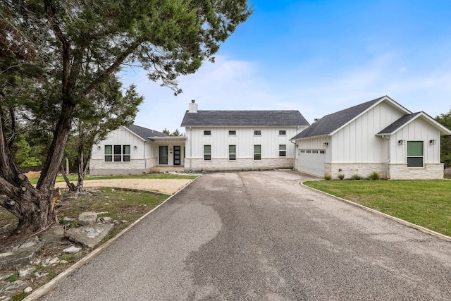 6601 N Lakewoods Dr, Georgetown, TX 78633 - modern inspired farmhouse featuring board and batten siding, asphalt driveway, a chimney, an attached garage, and french doors