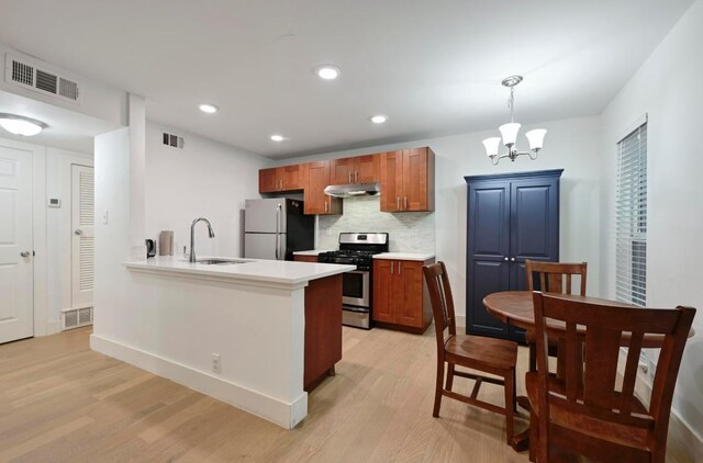 5820 Berkman Dr Unit 119, Austin, TX 78723 - kitchen featuring gas stove, freestanding refrigerator, a sink, under cabinet range hood, and light wood-type flooring
