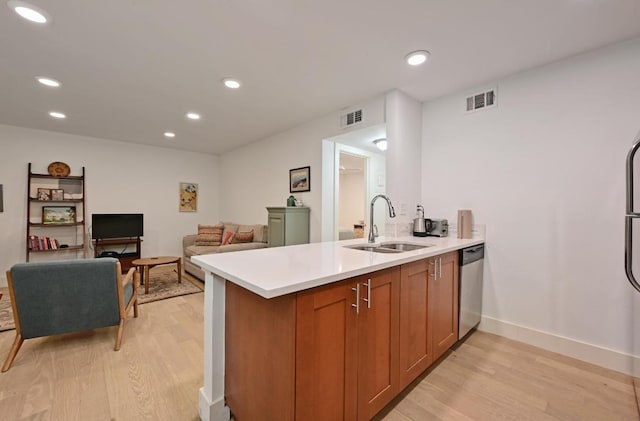 5820 Berkman Dr Unit 119, Austin, TX 78723 - kitchen with a sink, light wood-type flooring, light countertops, brown cabinets, and a peninsula