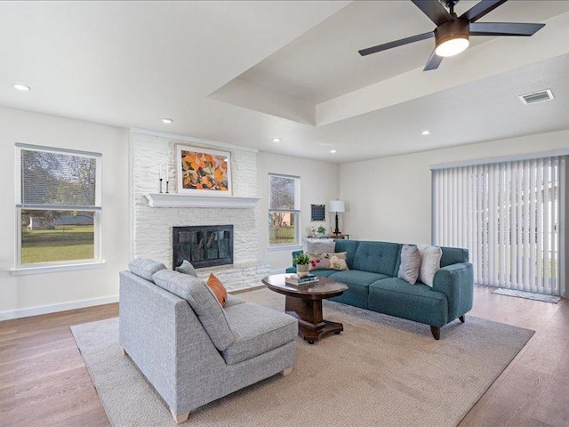 living room with a wealth of natural light, wood finished floors, and visible vents