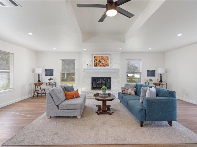 living room featuring a tray ceiling, wood finished floors, visible vents, and recessed lighting