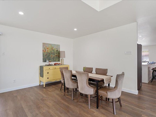 dining space featuring baseboards, wood finished floors, and recessed lighting