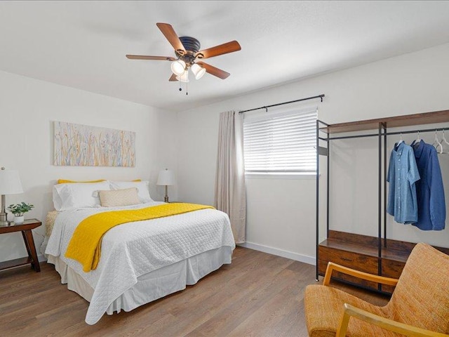 bedroom with baseboards, a ceiling fan, and wood finished floors
