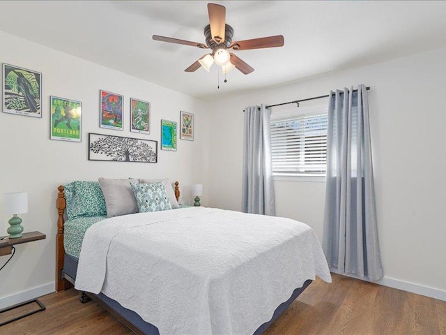 bedroom featuring wood finished floors, baseboards, and ceiling fan