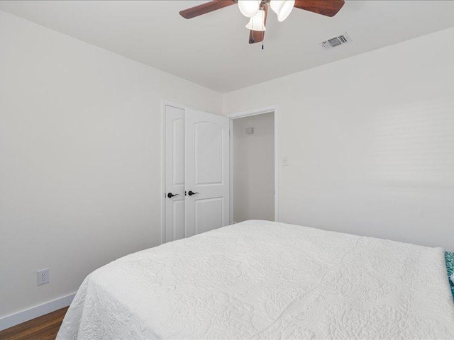 bedroom with baseboards, visible vents, a ceiling fan, and dark wood-style floors