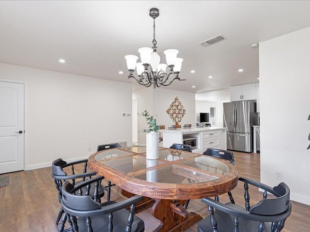 dining area featuring baseboards, visible vents, recessed lighting, a chandelier, and wood finished floors