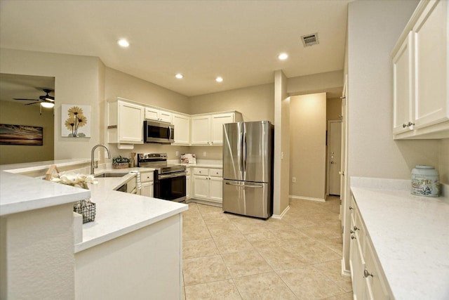 202 Whippoorwill Cv, Georgetown, TX 78633 - kitchen featuring stainless steel appliances, a sink, ceiling fan, white cabinetry, and recessed lighting