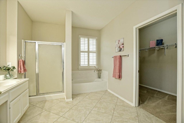 202 Whippoorwill Cv, Georgetown, TX 78633 - full bath featuring vanity, a stall shower, a walk in closet, a garden tub, and tile patterned flooring