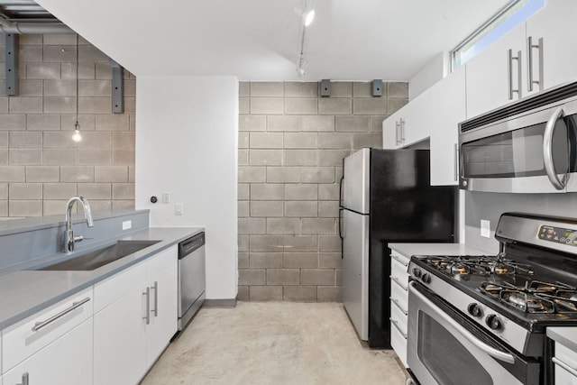 4801 S Congress Ave Unit H2, Austin, TX 78745 - kitchen with stainless steel appliances, white cabinetry, concrete flooring, light countertops, and track lighting