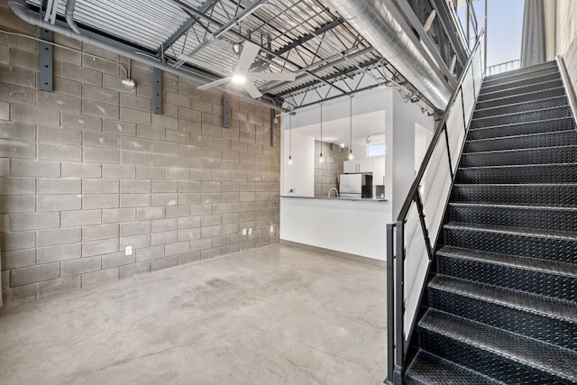4801 S Congress Ave Unit H2, Austin, TX 78745 - basement featuring freestanding refrigerator, concrete block wall, stairs, and a garage