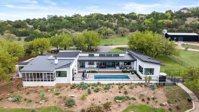 3931 R O Dr, Spicewood, TX 78669 - rear view of house with a fenced backyard, a sunroom, a patio area, stucco siding, and metal roof