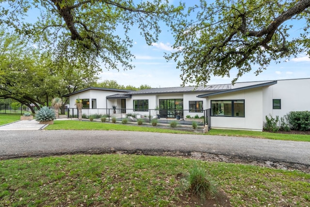3931 R O Dr, Spicewood, TX 78669 - view of front of house featuring stucco siding, a fenced front yard, metal roof, and a standing seam roof