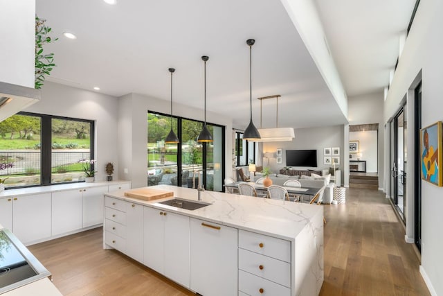 3931 R O Dr, Spicewood, TX 78669 - kitchen with a sink, light wood finished floors, white cabinetry, decorative light fixtures, and recessed lighting