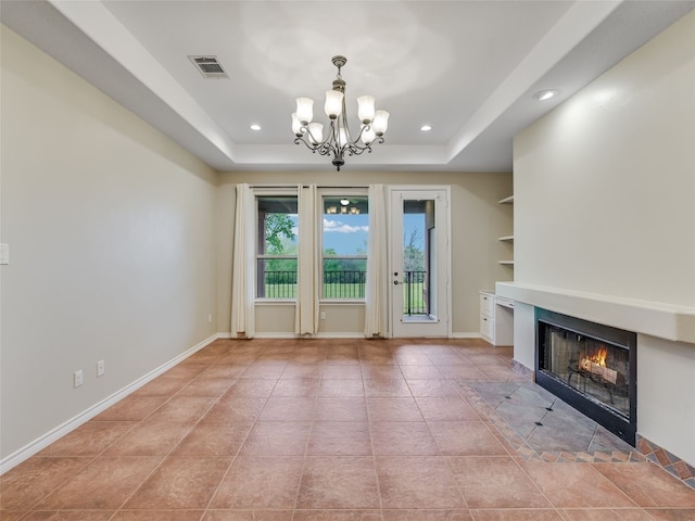 539 Colovista Pkwy Unit C103, Bastrop, TX 78602 - unfurnished living room with a chandelier, a fireplace with flush hearth, light tile patterned floors, a raised ceiling, and recessed lighting