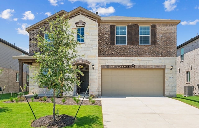 16824 Santiaguillo Trce, Manor, TX 78653 - view of front of house featuring driveway, an attached garage, stone siding, a front yard, and brick siding