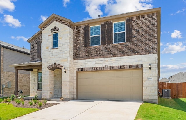 16824 Santiaguillo Trce, Manor, TX 78653 - view of front of home featuring concrete driveway, an attached garage, stone siding, and brick siding