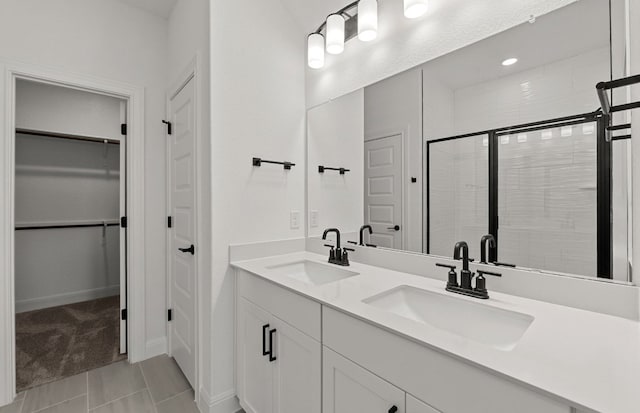 16824 Santiaguillo Trce, Manor, TX 78653 - bathroom featuring double vanity, a stall shower, and a spacious closet